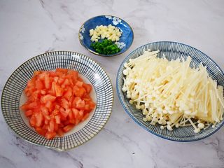 2、茄汁金针菇,西红柿先在顶部切十字，用开水烫至皮开，去皮切碎，金针菇去根部洗净备用，蒜切末，葱切葱花