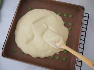 12、波点蛋糕卷,将原味面糊距离烤盘20厘米左右倒入；用刮刀将面糊铺平，震出大气泡