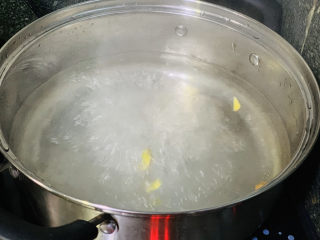 3、四季豆烧排骨,锅烧水，加姜片和料酒煮一会；