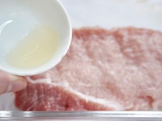1、爆浆黄金芝士猪排,猪里脊肉用刀切成两半拍松肉加入料酒