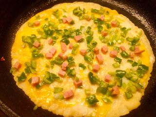 15、辣椒香葱午餐肉鸡蛋卷饼,小火慢慢煎至表面微黄,全部食材都会沾在蛋液上了。