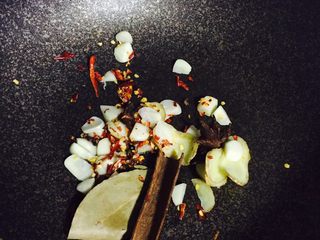 5、麻辣水煮鱼,锅中倒油,油热后倒入姜蒜、部分辣椒、部分花椒、八角、香叶、桂皮中火翻炒