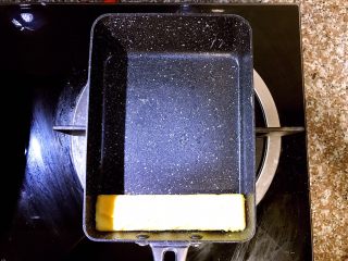 7、日式厚蛋烧,将第一层蛋饼卷在最下方成型后,准备开始倒入第二层蛋液