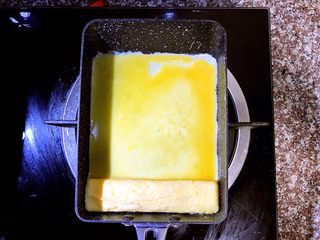 8、日式厚蛋烧,倒入蛋液的时候要注意刚卷好的蛋卷下方也要用筷子拨开让蛋液流入其底部哦