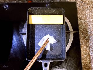10、日式厚蛋烧,卷到最上方,第二层蛋卷成型后准备倒入第三层蛋液。这里提一点需要注意的地方,每次倒入蛋液前如果发现锅内油不够了,就用之前吸了橄榄油的厨房吸油纸再在锅内均匀涂抹一层