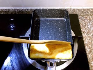 17、日式厚蛋烧,待第五层蛋卷卷好后用木铲轻压塑形