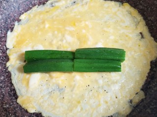 9、秋葵厚蛋烧,表面带干不干的时候放入秋葵，摆法如图