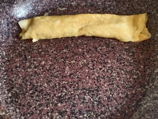 10、秋葵厚蛋烧,从底下小心翼翼的往上卷，尽量卷紧一点，最后成品会好看一些。卷到头