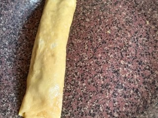 12、秋葵厚蛋烧,待表面带干不干的时候把秋葵卷往另一端卷起，如图