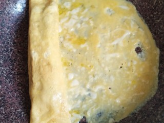 13、秋葵厚蛋烧,最后把剩余所有的蛋液沿着秋葵卷都倒进锅里，再卷起来。