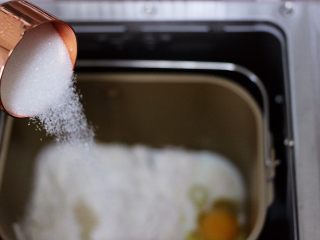 2、椰蓉奶香面包圈,把牛奶加入面包桶，再加入盐和甘汁园双碳白砂糖，（糖与盐对角放）再加入鸡蛋(鸡蛋重量约50g左右)最后加入高筋面粉和低筋面粉，面粉中间挖个洞，放入酵母粉，再用旁边的面粉把酵母粉盖起来。