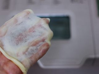 5、椰蓉奶香面包圈,揉至面团出现不容易破的手套膜即可。