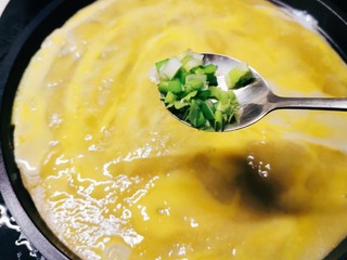 11、玉米渣煎饼,趁鸡蛋液还没有凝固 撒上葱碎