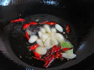 9、洋葱爆腰花,热锅注入油烧至6分热,放入蒜瓣、辣椒、生姜炸出香味