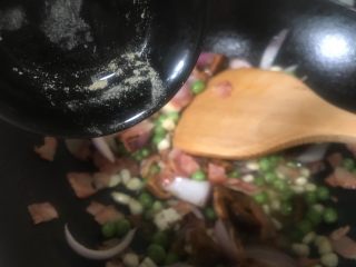 4、芝士培根焗饭,加入胡椒粉继续炒匀。