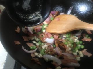 5、芝士培根焗饭,倒入生抽翻炒片刻，炒香炒熟食材。