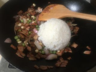 7、芝士培根焗饭,倒入米饭翻炒均匀。