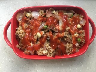 9、芝士培根焗饭,炒饭倒入烤盘里，挤上番茄酱。