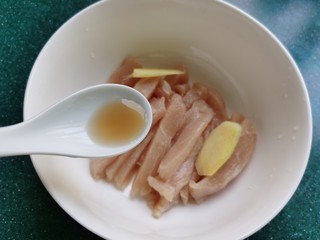 3、孜然鸡胸肉,加入少许盐和一勺料酒。