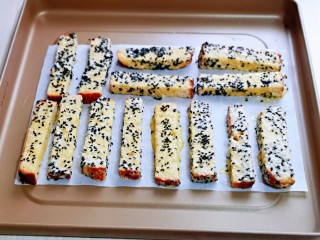 8、简单快手小零食～黑芝麻椰香吐司条,依次做完的吐司条，摆放垫油纸的烤盘中，并间隔距离。