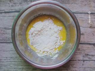 4、舒芙蕾松饼,筛入低筋面粉和2克泡打粉，用蛋抽画Z字搅拌均匀