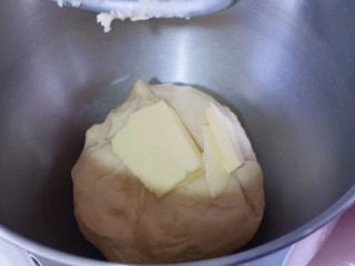 4、花式椰蓉面包,10分钟后面团处于扩展阶段，加入室温软化的黄油！再次启动厨师机，2档后面15分钟！