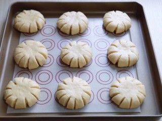 12、花式椰蓉面包,再用食品剪刀剪出，约1厘米的口子，距离要相等，这样才好看！放入垫有油纸的烤盘中，并间隔距离！