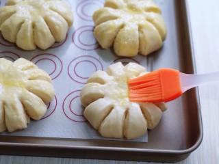 14、花式椰蓉面包,发酵好的面包胚取出刷上薄薄一层蛋液。