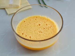 2、芝士培根鸡蛋卷,鸡蛋磕入碗中，加温水搅打均匀备用