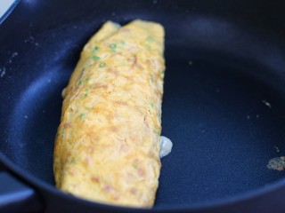 14、芝士培根鸡蛋卷,依照上面步骤把蛋卷再卷回来，两面稍微煎一下，出锅后切块食用即可