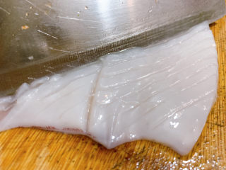 4、西芹炒鱿鱼,将鱿鱼中间切开,在鱿鱼内壁上斜切花刀