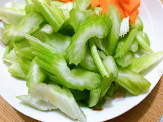 7、西芹炒鱿鱼,然后将西芹胡萝卜,先行入沸水中汆烫。