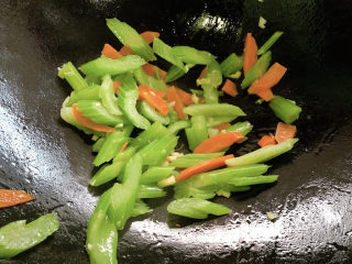 11、西芹炒鱿鱼,加入西芹胡萝卜,翻炒均匀。