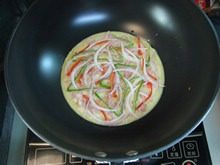 7、披萨蛋饼,接着铺上青红椒丝、洋葱丝。
