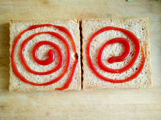 6、沼夫三明治,在吐司片上涂抹适量的番茄酱。