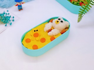 17、小熊便当套餐,再用海苔装饰上眼睛，用做被子剩下的蛋皮做了个小熊，还有鼻子，摆放上胡萝卜片，放上坚果即可。