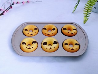 14、烘焙小白必做～萌狗甜甜圈,巧克力隔水融化，装入裱花袋，记得剪个很小很小的小口，手绘上眼睛与鼻子，嘴巴。