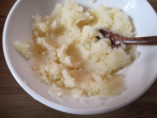 5、笑脸土豆饼,把蒸熟的土豆趁热压成泥。