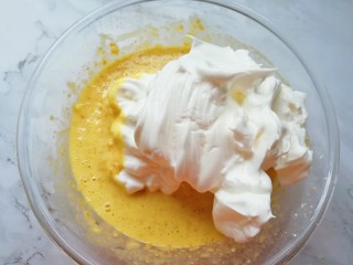 10、亚麻籽戚风蛋糕,打发好的蛋白分成三份，取中间的三分之一加入到亚麻籽蛋黄糊里面，用硅胶刮刀采用切拌和翻拌的方法混合均匀。