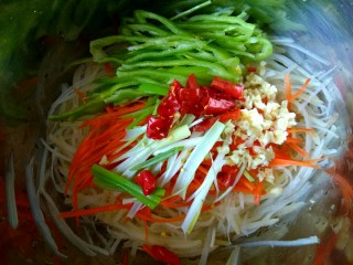 8、香辣凉拌三丝,把土豆丝胡萝卜丝控干水份放入盆中 加入尖椒丝，加入葱蒜干红辣椒