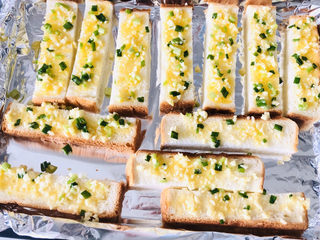 5、简单几步，做出媲美面包店的蒜香面包条,刚刚调好的蒜蓉黄油料均匀铺在吐司条上。