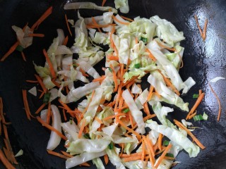 13、十味 鲜虾鱼板面,下入卷心菜和胡萝卜丝翻炒至胡萝卜变软，卷心菜开始变色。