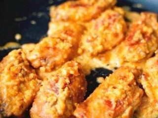 15、咸蛋黄鸡翅,把鸡翅倒进去,不断翻炒,让鸡翅裹满咸蛋黄