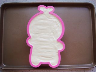 12、白梨卡通蛋糕,把翻拌好的糊糊倒入模具中，在台面上镇几下，镇出大气泡，用竹签左右“Z”字形划掉小泡泡。（如果多余出了量就倒入纸杯里一起烘烤。）