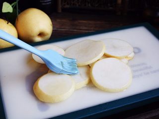 3、百变水果 柠香酸奶佐蜂蜜烤梨配法棍面包,在每片雪梨的正反两面豆刷上薄薄的一层蜂蜜。