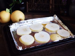 5、百变水果 柠香酸奶佐蜂蜜烤梨配法棍面包,将梨片平铺在烤盘上。