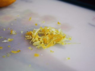 9、百变水果 柠香酸奶佐蜂蜜烤梨配法棍面包,用刮皮刀将黄柠檬的皮刮成柠檬皮屑。