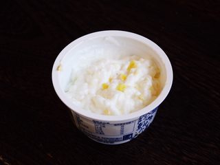 11、百变水果 柠香酸奶佐蜂蜜烤梨配法棍面包,将柠檬皮屑放在酸奶杯里，用小勺搅拌均匀。