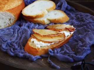 14、百变水果 柠香酸奶佐蜂蜜烤梨配法棍面包,将烤好的蜂蜜梨片对折，放在法棍面包片上。