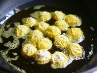 6、年夜饭必备之腰缠万贯,锅中下半锅油,烧至五成热,放入包裹好的鹌鹑蛋小火慢炸,边炸边轻轻晃动锅。